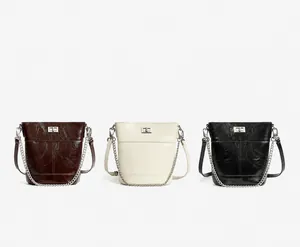 Présentation détaillée des sacs seaux en marron, blanc et noir en cuir huilé brillant