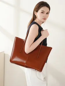 Brown large capacity leather tote bag with glossy finish and long shoulder straps