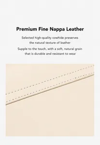 Detail view of premium cowhide leather with precise white stitching on beige crescent bag