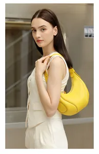 Dettaglio della borsa hobo in pelle gialla con cuciture bianche e zip in metallo argento