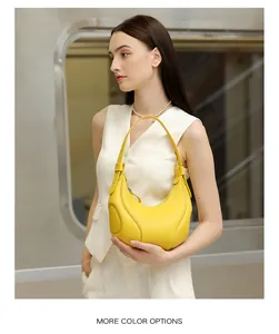 Elegante borsa a mezzaluna in pelle gialla a grana litchi indossata da una modella