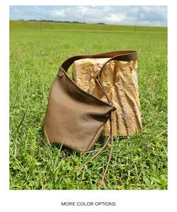 Dettaglio della pelle a grana litchi su una borsa a tracolla minimalista verde scuro