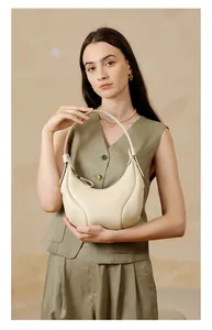 Dettaglio borsa a tracolla beige a mezzaluna con trama a grana e cuciture curve