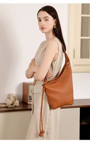 Dettaglio borsa hobo in pelle martellata marrone con coulisse e tracolla larga