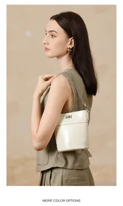 Détail du sac seau en cuir ciré crème avec fermoir argenté et bandoulière chaîne