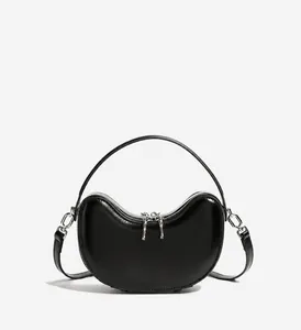 Close-up of black leather dumpling bag showing silver hardware and smooth texture