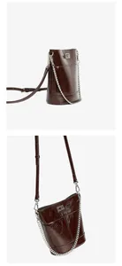 Détail du sac seau en cuir marron foncé avec ferrures argentées et texture brillante