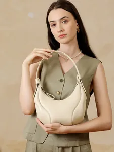 Elegante borsa hobo a mezzaluna in pelle color crema con grana naturale su modella