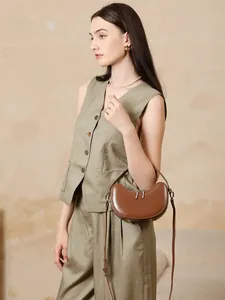 Dark brown leather crescent bag featuring minimalist design with smooth finish for women