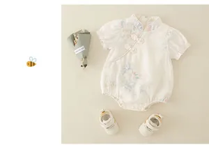 Detail of vintage Chinese style floral baby romper with traditional frog buttons and shoes