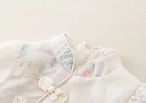 Detail of vintage Chinese style baby bodysuit with floral print and traditional knots
