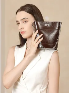 Sac seau vintage en cuir ciré marron foncé avec bandoulière chaîne porté par mannequin