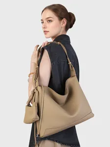 Borsa hobo minimalista in pelle kaki con portamonete coordinato indossata da modella