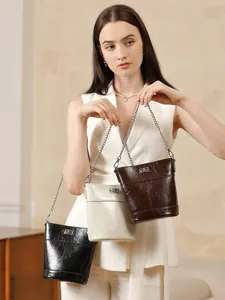 Sac seau moderne en cuir ciré noir, beige et marron avec bandoulière en chaîne