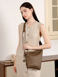 Borsa a tracolla minimalista in pelle marrone con nodo asimmetrico indossata
