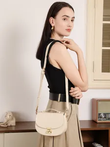 Elegant cream leather half-moon shoulder bag with gold clasp shown on model