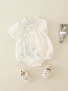 Vintage Chinese style baby romper with floral print and matching shoes on beige background