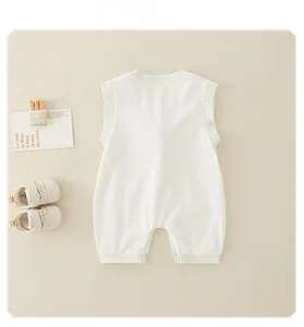 Detail of baby sleeveless cotton romper with soft green ribbed trim on beige fabric