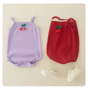 Detail of cotton baby bodysuits with lace collar and knitted cherry decorations