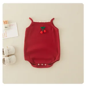 Detail of red baby bodysuit featuring lace collar, cherry knit décor, and bottom snaps