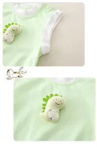 Detail of light green baby bodysuit featuring a 3D dinosaur patch and resin snap buttons