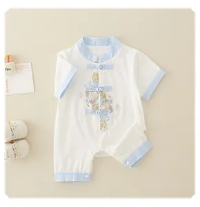 Detail of newborn cotton romper with traditional embroidery and frog button closures