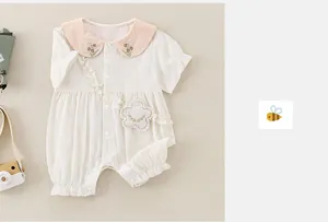 Detailaufnahme des Baby-Stramplers mit Gänseblümchen-Stickerei und kleiner Blumentasche