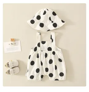Detail of baby cotton romper set featuring large black polka dots and matching sun hat