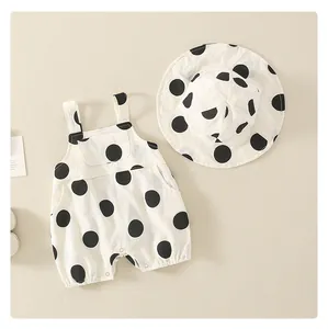 Detailed macro view of white sleeveless baby romper and sun hat with black polka dots