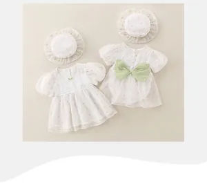 Detalle en plano de vestido veraniego floral para bebé con sombrero y borde de encaje
