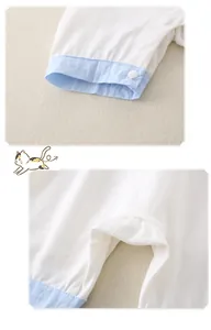 Detail of newborn cotton bodysuit showing white resin snaps and soft blue trim edges