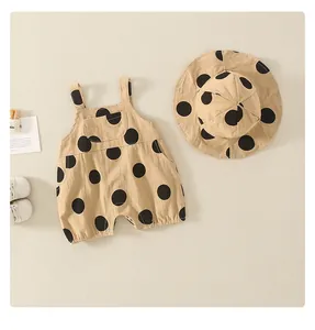 Baby cotton romper with matching sun hat featuring large black polka dots and pockets