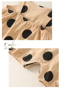 Detailed macro view showing the snap button closure and linen texture of a polka dot romper