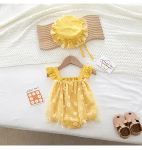 Detail of yellow baby romper and matching sun hat with white daisy floral patterns