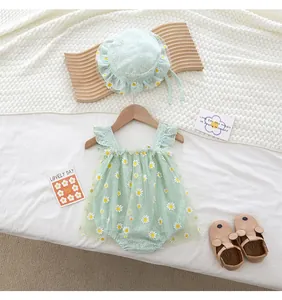 Detail of mint green baby romper with white daisy embroidery and matching sun hat