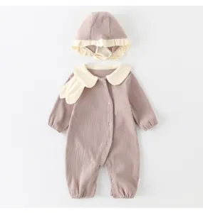 Flat lay of cotton baby bodysuit set with ruffled hat in soft mauve ribbed fabric
