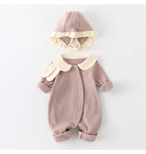 Detail of ribbed cotton baby romper and matching hat with ruffle edges and Peter Pan collar