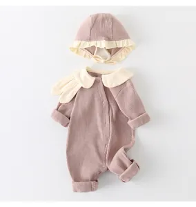 Detailed view of pink ribbed cotton baby romper with decorative cream ruffled edges