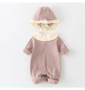 Detailed close-up of baby romper in dusty pink ribbed cotton with ruffled collar