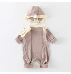 Detail of ribbed cotton baby romper and matching ruffle hat set in mauve and beige