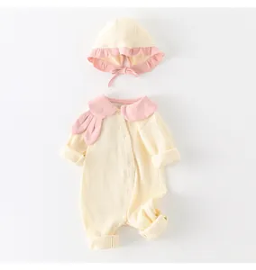 Flat lay of baby girl cotton jumpsuit with rabbit ear collar and matching knitted hat