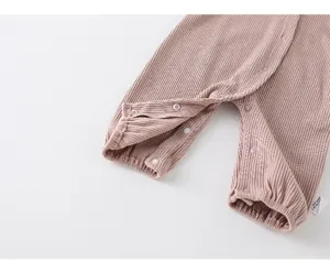 Detail of pink ribbed cotton baby romper featuring snap button closures for easy changes
