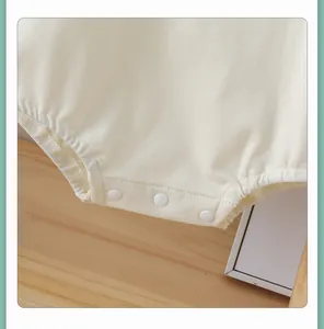 Detail of baby cotton bodysuit with reinforced snap buttons and neat stitching