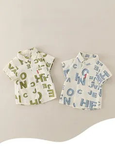 Detailaufnahme flach gelegter Baumwoll-Leinen-Shirts mit kunstvollen Buchstabenmustern