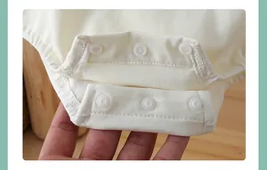 Detail view of cotton baby bodysuit with triple snap closure for easy diaper changes