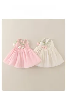 Detail of pink and cream gauze pet dresses with tulip pendants and crossover straps