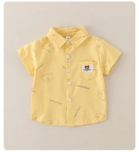 Close-up of yellow children's shirt featuring cute bear patterns and a chest pocket label