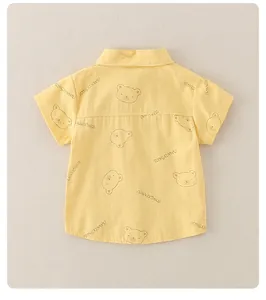 Close-up of child's yellow short-sleeved shirt featuring cute bear patterns and prints