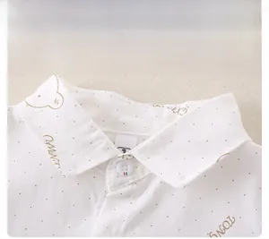 Detail showing white shirt collar with gold bear prints and smooth cotton fabric texture