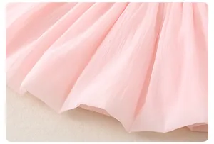 Detail of pink pleated chiffon fabric showing delicate texture on a baby girl summer dress
